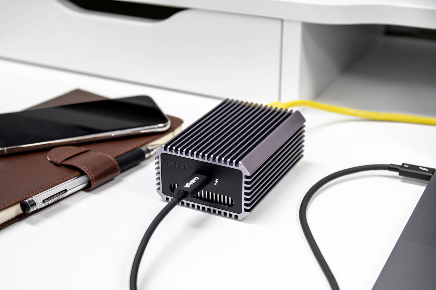 A Connect-10G on a table connect to a Thunderbolt computer on one side and to ethernet on the other side.